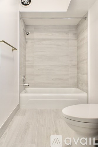 A bathroom with a white tub and toilet.