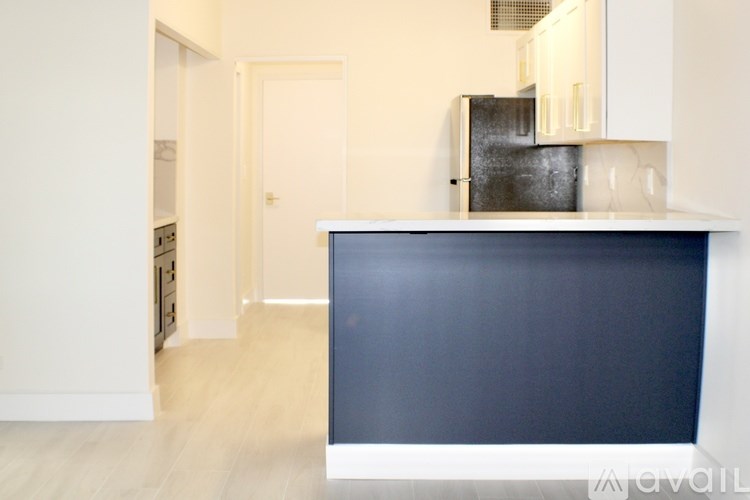 A kitchen with a dark blue countertop and white cabinets.