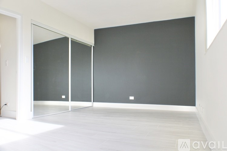 A room with a grey wall and a white floor.