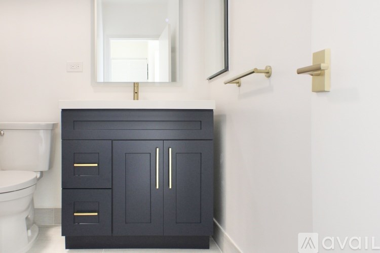 A black cabinet with a mirror above it in a bathroom.