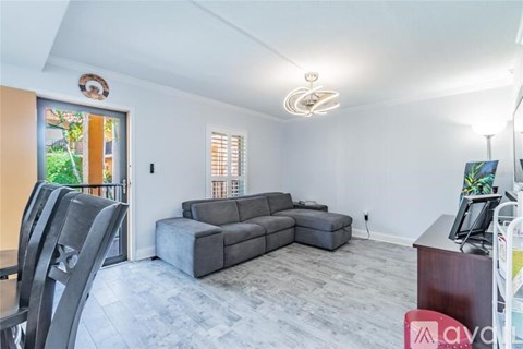 A living room with a grey sofa and a wooden desk.