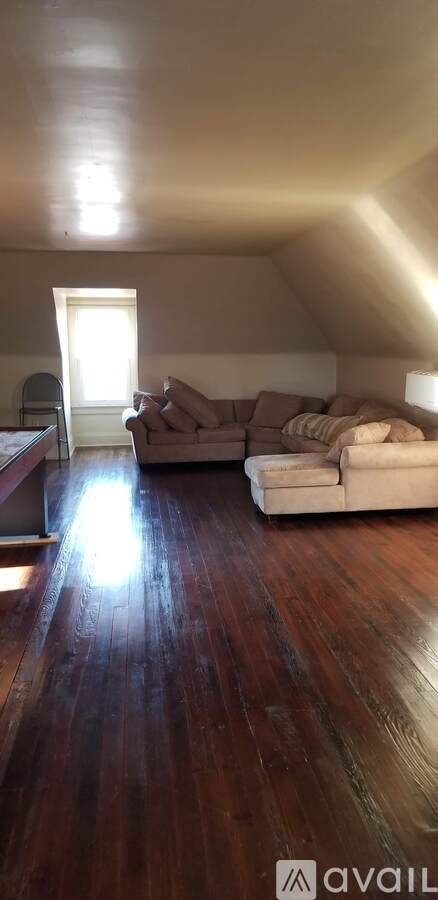 A living room with a couch and a wooden floor.