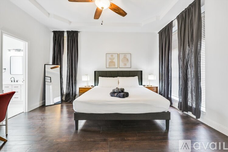 A bedroom with a large bed and a ceiling fan.