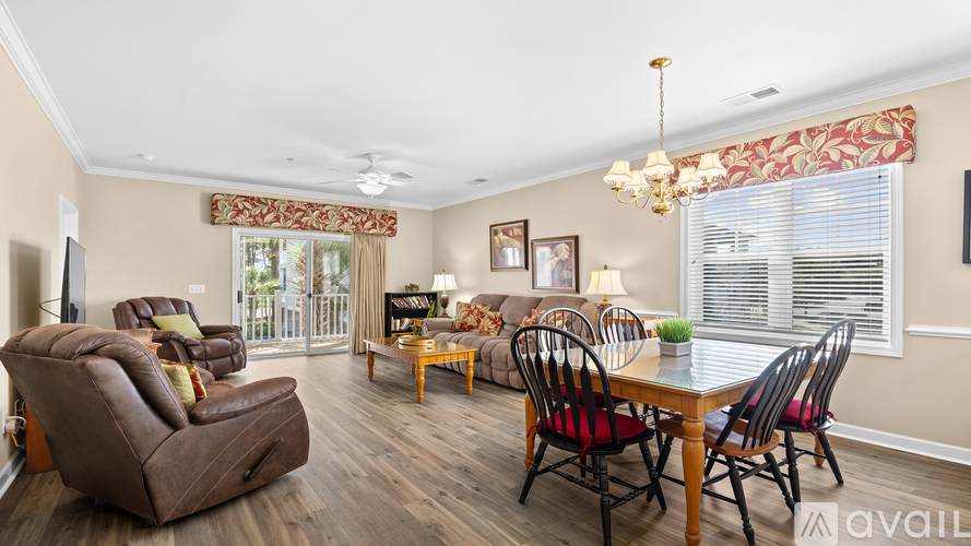 A living room with a green couch and a ceiling fan.