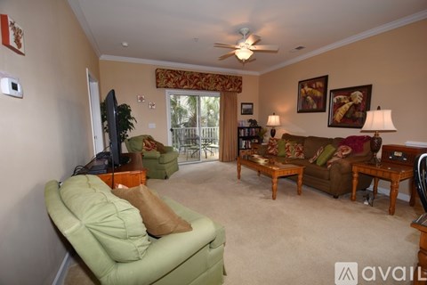 A living room with a green couch and a ceiling fan.