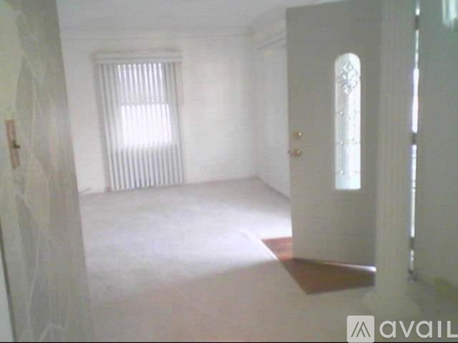 A room with a window and a door is available for rent.