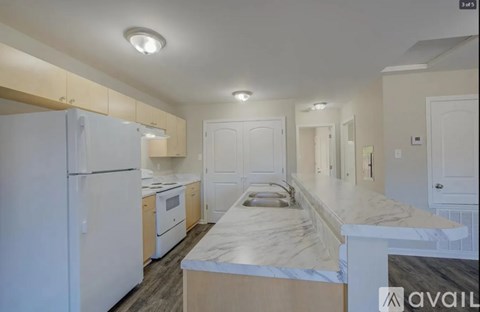 A kitchen with white appliances and a marble countertop.