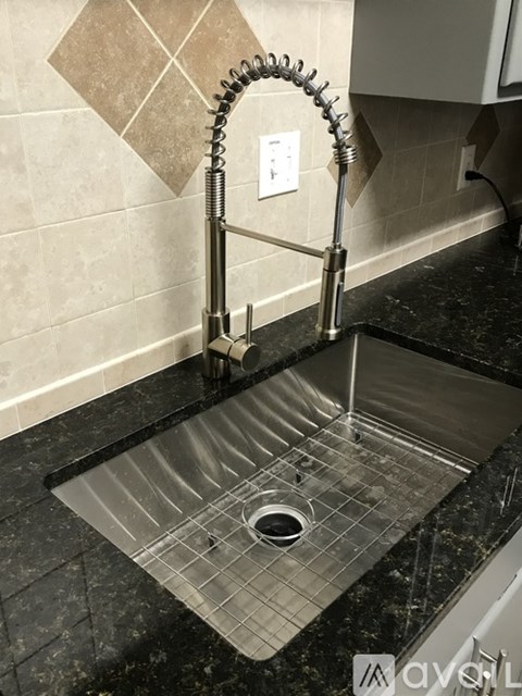 A kitchen sink with a metal faucet.