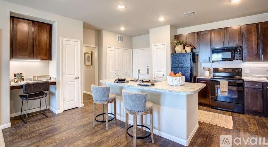 A kitchen with a white island and dark wood cabinets.