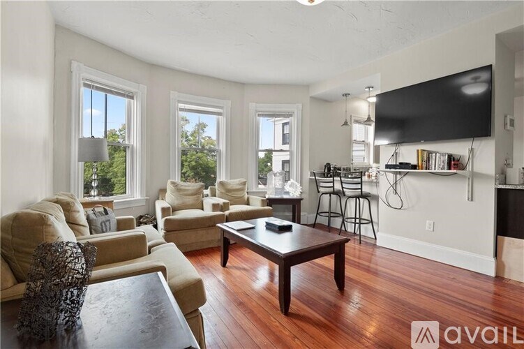 A living room with a couch, chairs, and a coffee table.