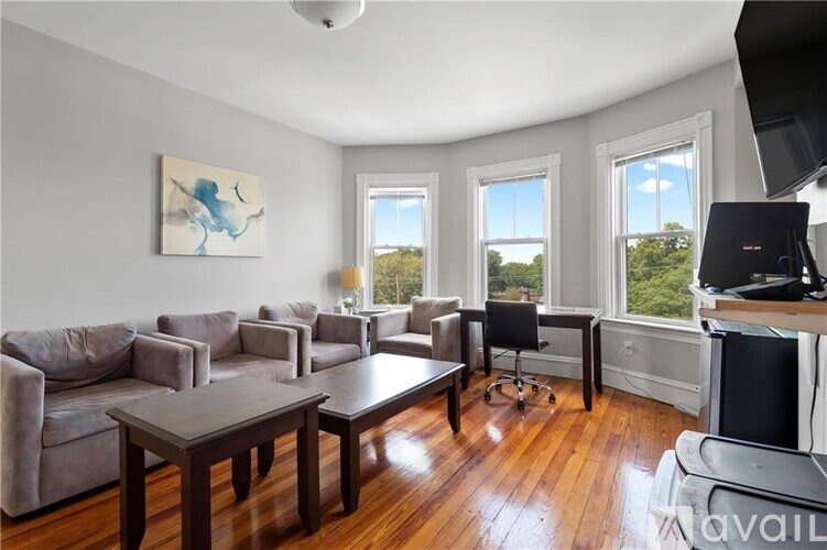 A living room with a grey couch, a brown coffee table, and a painting on the wall.