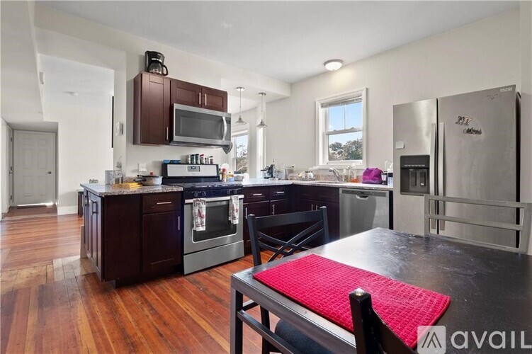 A kitchen with dark wood cabinets and a red mat on the table.