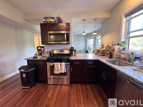 A kitchen with dark wood cabinets and a red mat on the table.