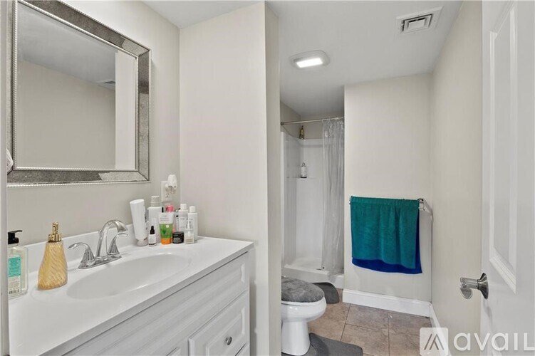 A bathroom with a white sink and a toilet.
