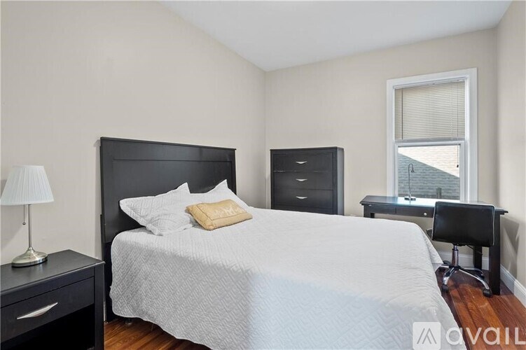 A bedroom with a bed, desk, and chair.