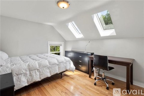 A bedroom with a large bed and a black dresser.