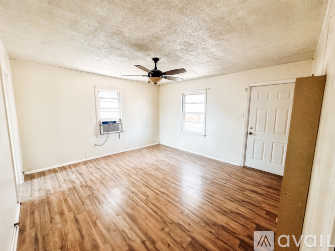 A room with wooden floors and a ceiling fan.