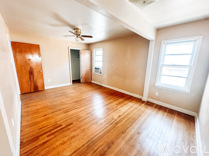 A room with wooden floors and a ceiling fan.