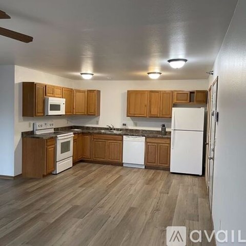 A kitchen with wooden cabinets and white appliances.