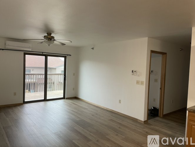 A room with a ceiling fan and sliding glass doors.