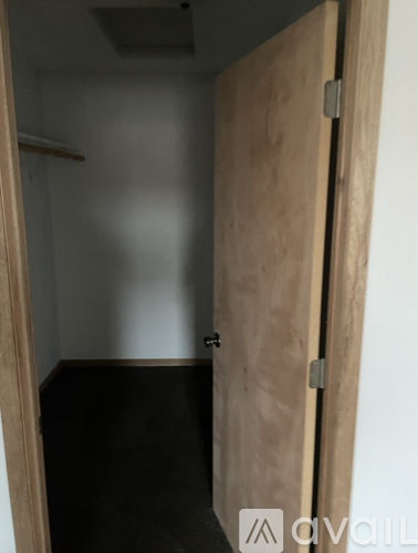 A wooden door is open to a dark room.