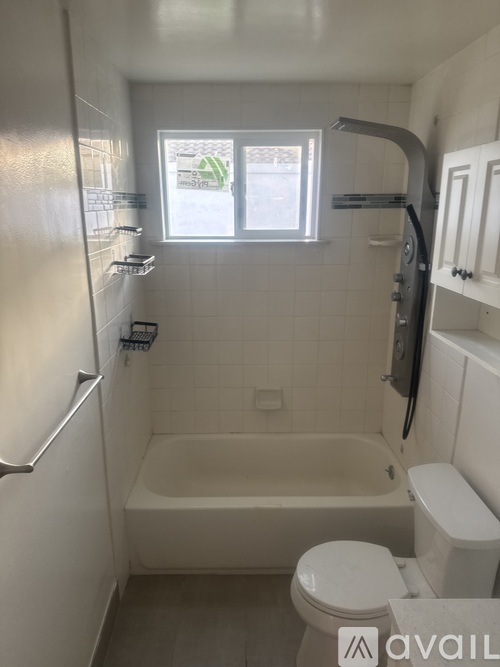 A small bathroom with a toilet, tub, and sink.