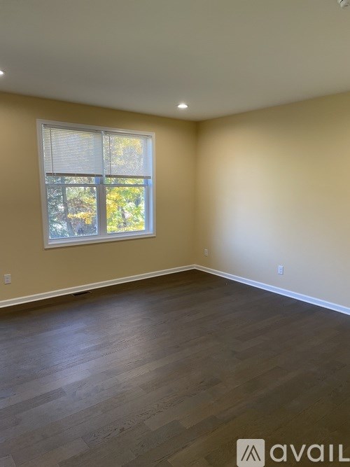 A room with a window and wooden flooring.