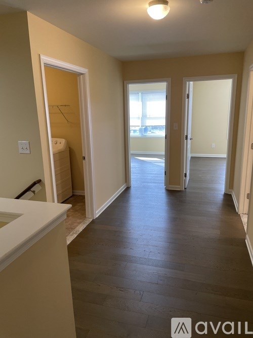 A long hallway with a white counter on the left and a door on the right.