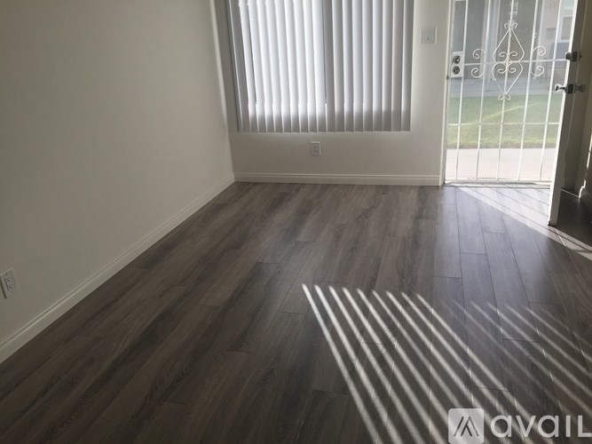 A room with wooden flooring and a white door.