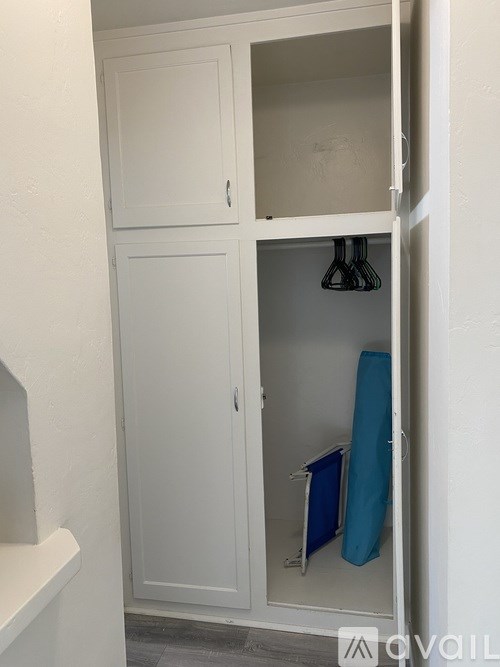 A white cabinet with a towel hanging on a rack.