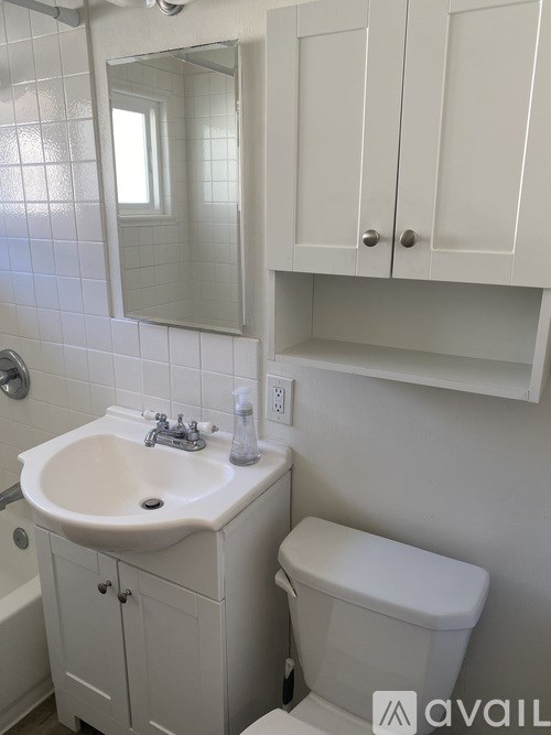 A white bathroom with a sink, toilet and mirror.