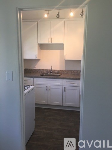 A kitchen with white cabinets and a granite countertop.