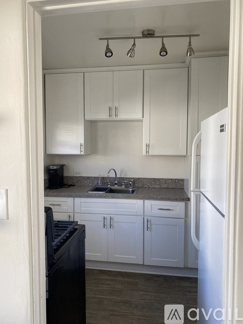 A white door is in a hallway with a white wall and a white air vent.