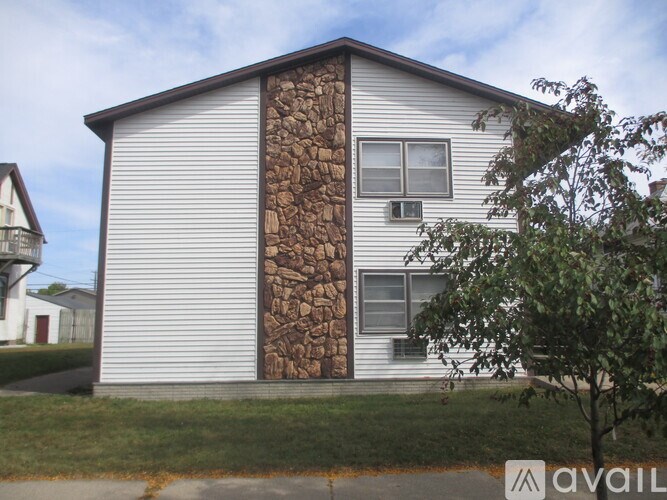 A house with a large log wall on the side.