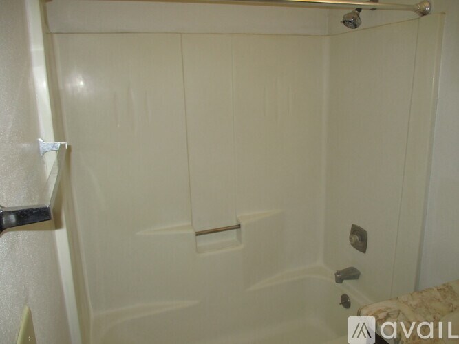 A white bathroom with a shower and a toilet.