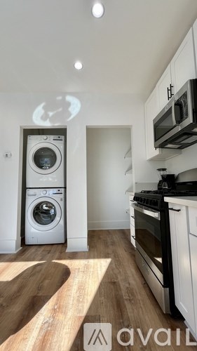 A modern kitchen with a washing machine and oven.