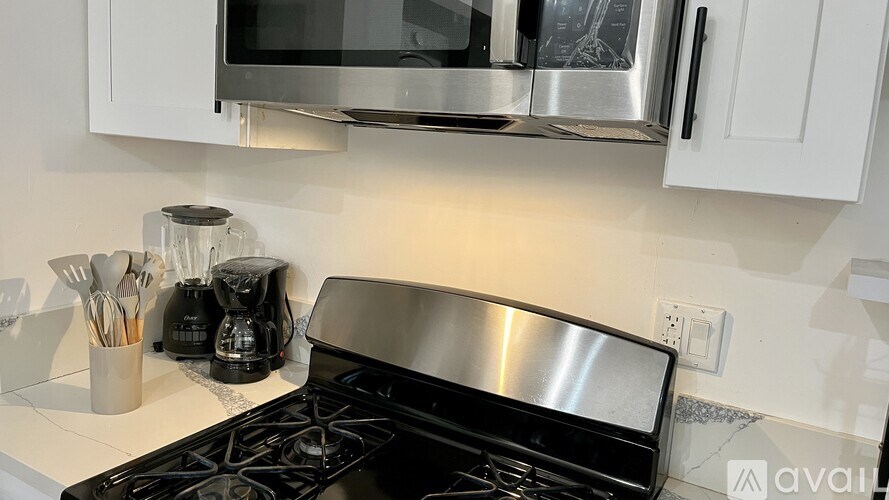 A modern kitchen with a stove top oven and a microwave above it.