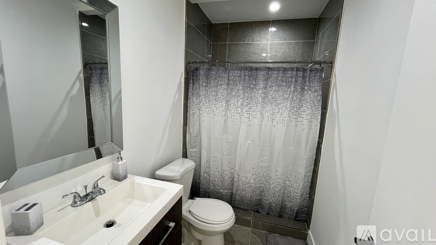 A bathroom with a white sink, toilet, and a shower with a glass door.