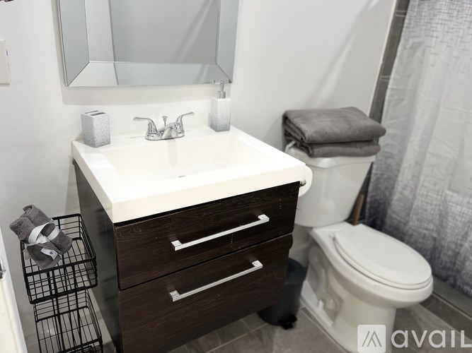 A white sink with a silver faucet and a mirror above it.