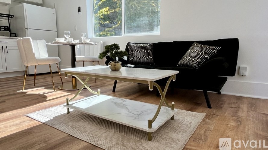 A black couch with a white coffee table in front of it.