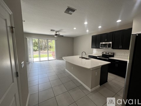 A kitchen with black cabinets and a white countertop.