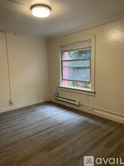 A room with a window and wooden flooring.