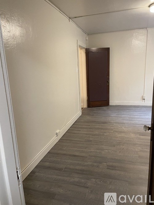 A room with a wooden door and grey flooring.
