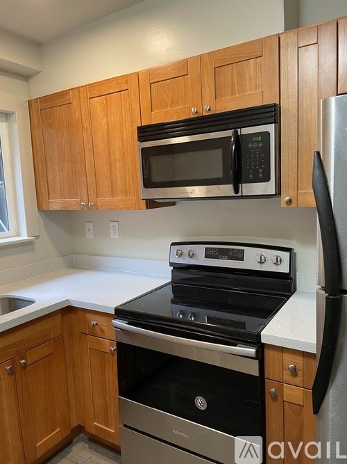A kitchen with wooden cabinets and a black stove top oven.