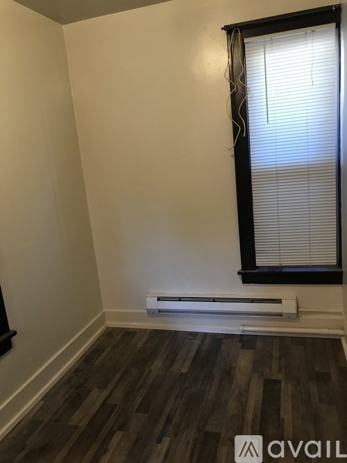A room with a window and a radiator on the floor.