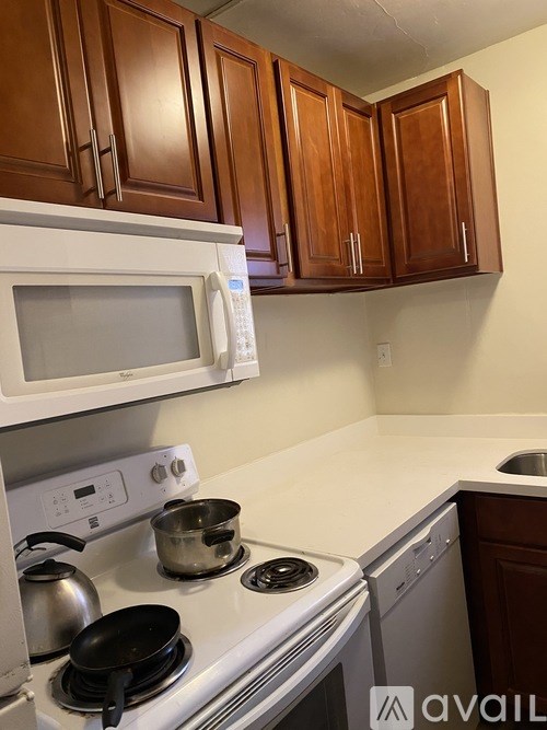 A kitchen with a white stove top and a white microwave above it.