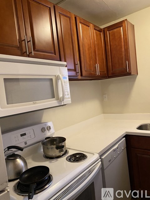 A kitchen with a white stove top and a white microwave above it.