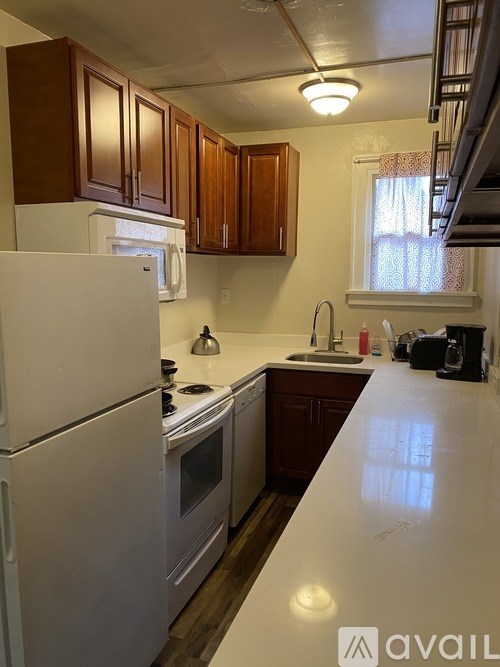 A kitchen with white appliances and wooden cabinets.