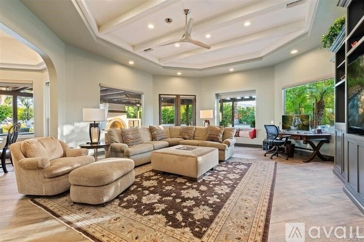 A spacious living room with a large sectional sofa and a rug.