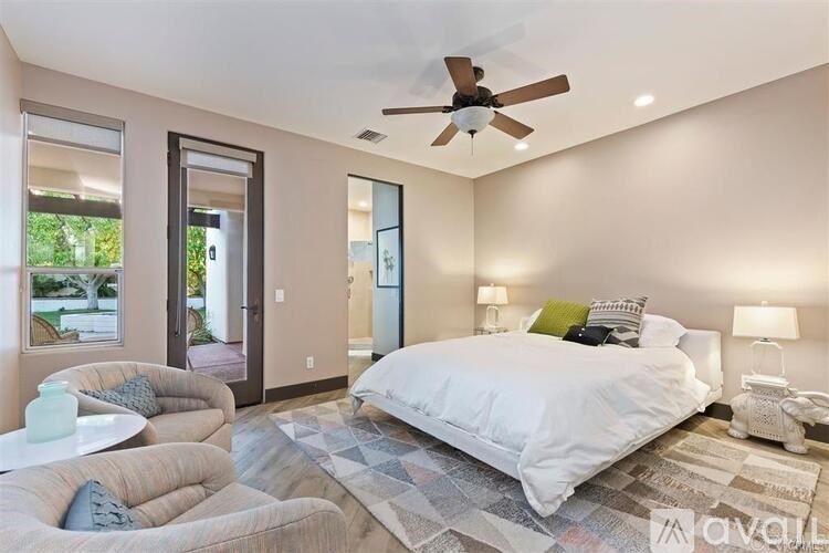 A bedroom with a large bed and a ceiling fan.